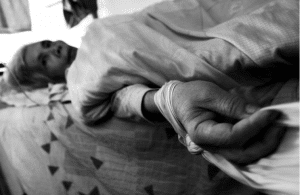 An elderly person lays helpless because of negligence, abuse, and neglect caused by over-medication in a nursing home.